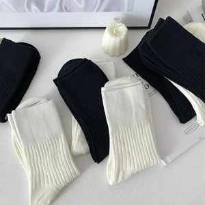 Detailed view of black and white ribbed cotton socks stacked on a stylish background