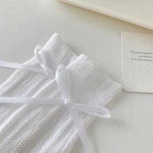 Détail de chaussettes blanches en maille style ballet avec ruban satiné et texture