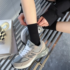 On-feet view of gray retro running sneakers with mesh and suede texture details