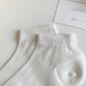 Gros plan de chaussettes blanches côtelées avec texture respirante et bord élastique