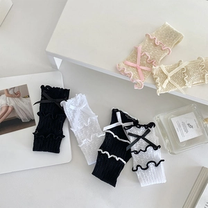 Vue détaillée des chaussettes en dentelle avec petits nœuds et bords à volants ondulés