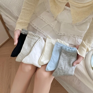Close-up of 6-pair set featuring ruffled lace cuffs and woven bow patterns on cotton socks