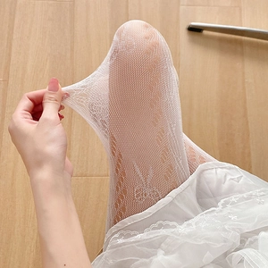 Détail de collants en dentelle ajourée blanche montrant une grande élasticité