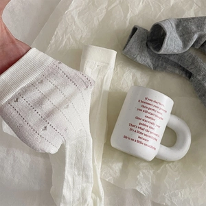 Gros plan de chaussettes d'été blanches avec motifs cœurs et texture en maille respirante
