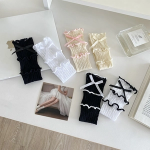 Détail de chaussettes en dentelle avec motif en maille ajourée et jolis nœuds décoratifs