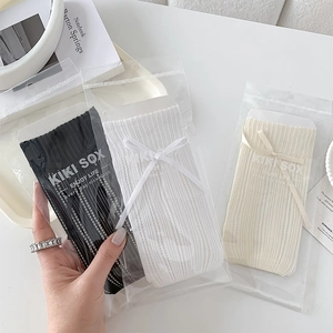 Détail de chaussettes style ballerine en résille avec rubans à nœuds et maille ajourée
