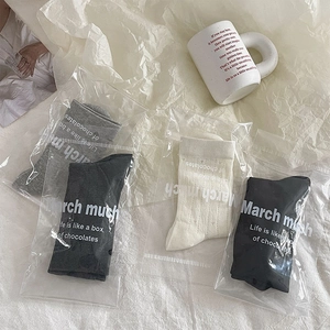 Détail de quatre paires de chaussettes ajourées en noir, gris et beige style écolière