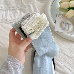 Close-up of layered ruffle cuffs and bow jacquard pattern on these sweet girls' socks