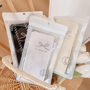 Lot de trois collants tricotés pour bébé en noir, blanc et beige dans des sacs zippés