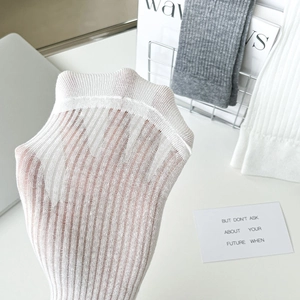 Detail of white ribbed calf socks showing elastic sheer fabric texture and knit quality