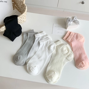Détail de la texture en maille côtelée des chaussettes en coton pour femmes en tons pastels
