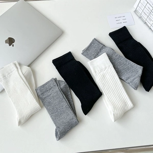 Détail de chaussettes en coton côtelé noir, blanc et gris avec une texture fine