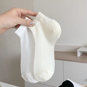 Détail macro de chaussettes courtes côtelées blanches et beige en coton doux
