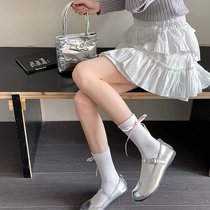 Détail de chaussures Mary Jane argentées avec chaussettes à nœud et jupe à volants