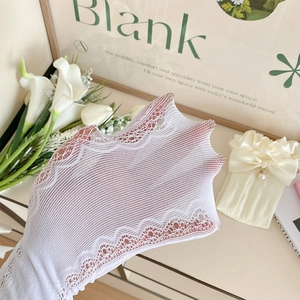 Détail de chaussettes blanches en maille dentelle avec nœud décoratif et pendentif perle