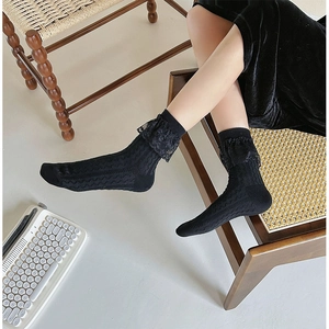 Gros plan de chaussettes mi-mollet noires avec bordure en dentelle et maille verticale