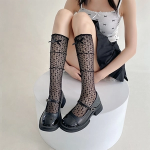 Détail de chaussettes résille en dentelle noire avec nœud et chaussures Mary Jane