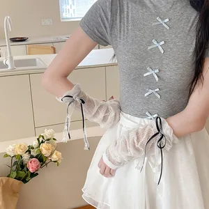 Détail de manchettes en dentelle blanche avec mesh plissé et petits nœuds noirs