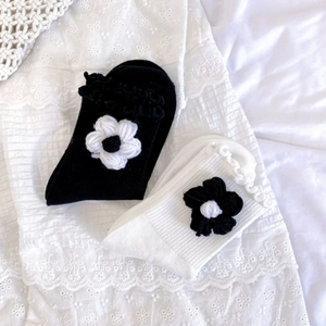 Detail of knit socks with 3D handmade crochet flowers and ruffled lettuce edges