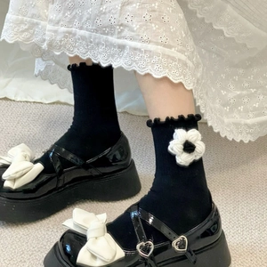 Black mid-calf Lolita socks with handmade white flowers and frilled edges worn with shoes