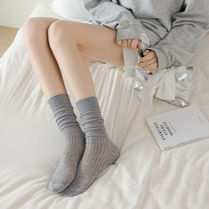 Gros plan détaillé de chaussettes grises à côtes montrant la texture douce du coton