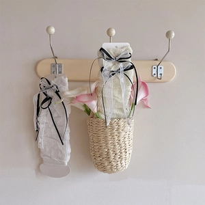 Détail de jambières Lolita crème avec nœuds en dentelle suspendus à des crochets