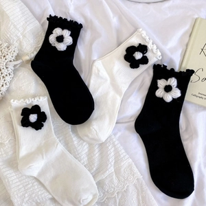 Detail of sweet knit crew socks with 3D floral accents and ruffled lettuce edge trim
