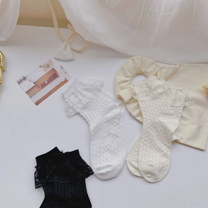 Détails de la bordure en dentelle et du motif jacquard sur chaussettes blanches et noires