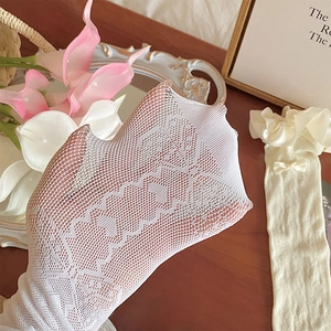 Close-up of white lace mesh socks with heart patterns, bow detail and ruffled edges