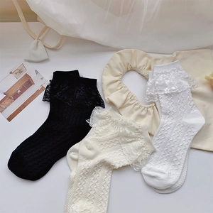 Détail de chaussettes mi-hautes blanches en maille ondulée avec bordure en dentelle