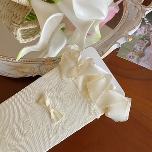 Detail of cream lace calf socks with silk ruffle edges and delicate bow accents
