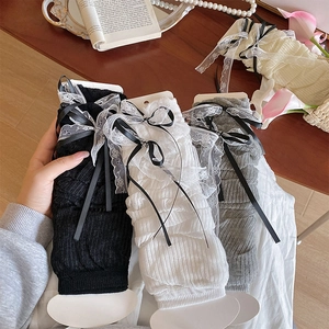Détail des manchettes Lolita avec dentelle et nœuds en noir, blanc et gris