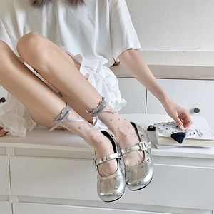 Detailed view of sheer polka dot tulle socks with bows and silver Mary Jane shoes