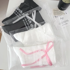 Détail de chaussettes montantes JK en sacs cadeaux avec nœuds décoratifs et emballage chic