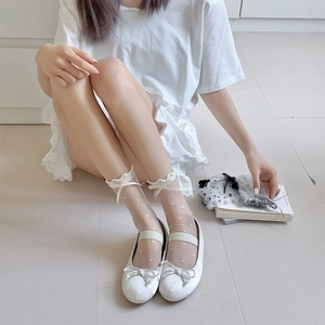 Detail of white sheer mesh socks with polka dots, frill trim and ribbon bow decoration