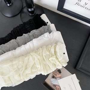 Detail of four-color pleated sun protection sleeves in black, grey, white and beige