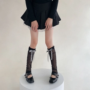 Dettaglio di scaldamuscoli in pizzo con fiocchi e scarpe Mary Jane stile balletto