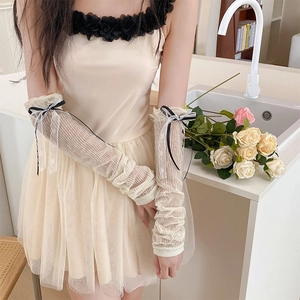 Manchettes en dentelle crème style Lolita avec nœuds noirs dans un décor doux