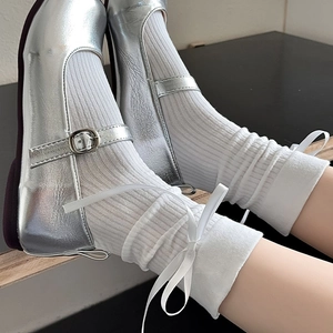 Chaussures Mary Jane argentées avec chaussettes à nœud blanc vues de profil
