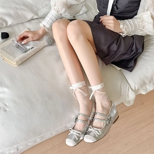 Silver Mary Jane flats with crystal buckles and white sheer bow socks on soft white fabric