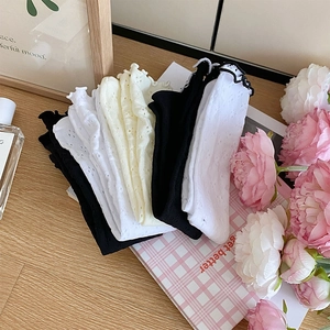 Détail des volants et motifs fleuris ajourés sur chaussettes en coton en plusieurs couleurs