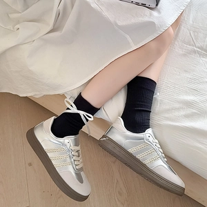 Vue de dessus de baskets rétro en cuir argent et blanc avec semelles classiques en gomme