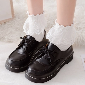 Close-up of white Lolita socks with double-layer lace embroidery and black leather shoes