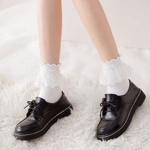 White Lolita lace trim mid-calf socks styled with black leather shoes on plush carpet