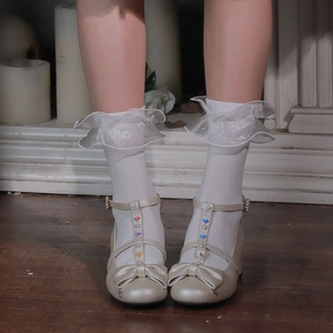 Détail de chaussettes en résille à dentelle blanche avec chaussures Mary Jane et bijoux
