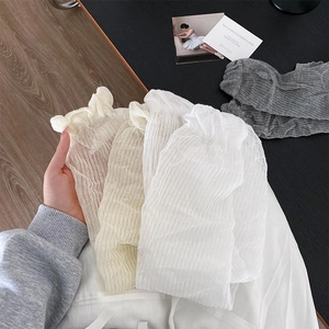 Detailed close-up of breathable thin arm sleeves with elegant ruffled lettuce edges