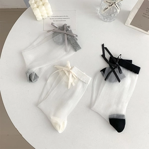 Detailed view of sheer mesh socks with bows in white, grey, and black color set