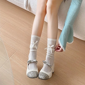 Detail of white hollow lace stockings with ribbon bows and Mary Jane shoes