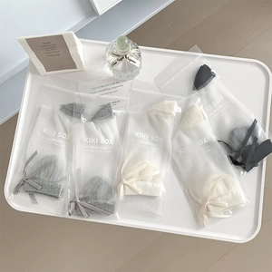 Detail of sheer crystal socks with silk ribbons in five colors and gift packaging