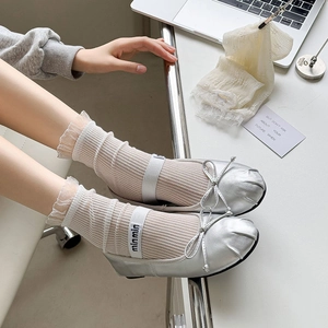Silver patent Mary Jane flats with bow detail paired with white lace mesh ankle socks